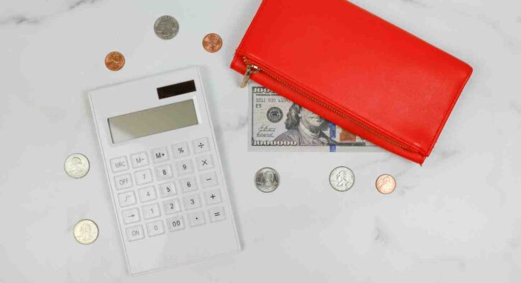 Calculator, wallet and cashused for budgeting and saving money on the low income