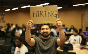Person holding a hiring sign representing companies recruiting professionals with in- demand remote work skills