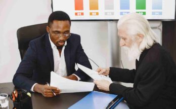Two professionals reviewing documents together to make a well formed decision.