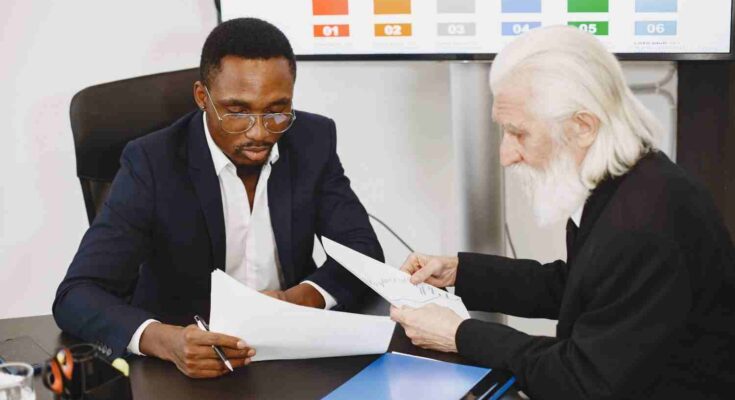 Two professionals reviewing documents together to make a well formed decision.